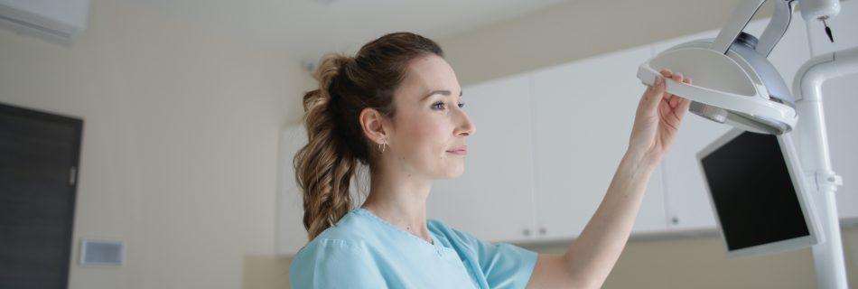 "Nurse in a hospital room, standing next to medical equipment"